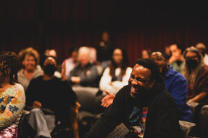 Audience members laughing and smiling